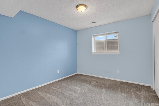 carpeted spare room featuring a textured ceiling