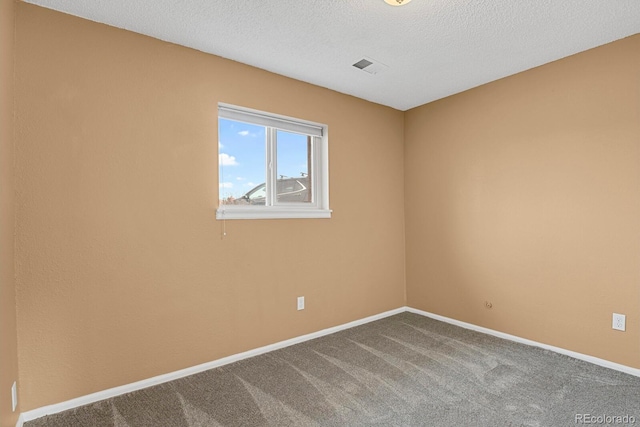 carpeted spare room featuring a textured ceiling