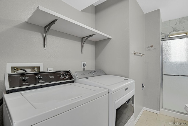 laundry room with separate washer and dryer and light tile patterned flooring