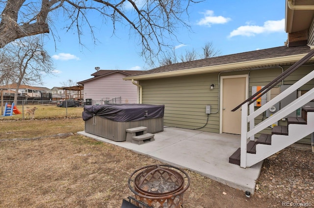 view of home's exterior with a patio, a hot tub, and a fire pit