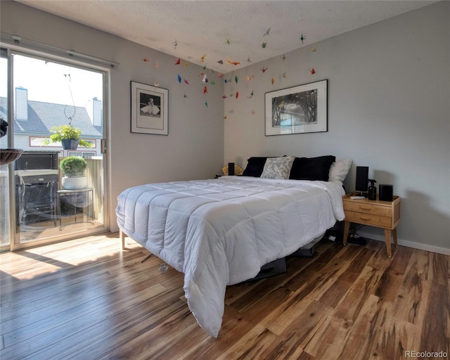 4110 Hale Pkwy Unit 5G, Denver, CO 80220 - bedroom featuring access to outside, wood finished floors, and a textured ceiling