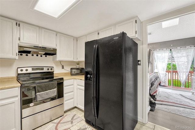 kitchen with light countertops, black refrigerator with ice dispenser, white cabinetry, stainless steel range with electric stovetop, and under cabinet range hood