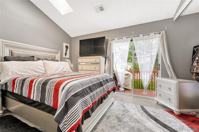 bedroom featuring access to exterior, visible vents, light wood-style flooring, a textured ceiling, and vaulted ceiling with skylight