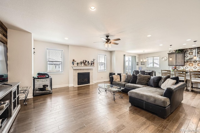 living room featuring wood-type flooring, a ceiling fan, recessed lighting, and a healthy amount of sunlight