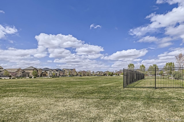 view of yard featuring fence and a residential view