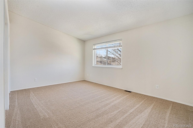 carpeted spare room with a textured ceiling