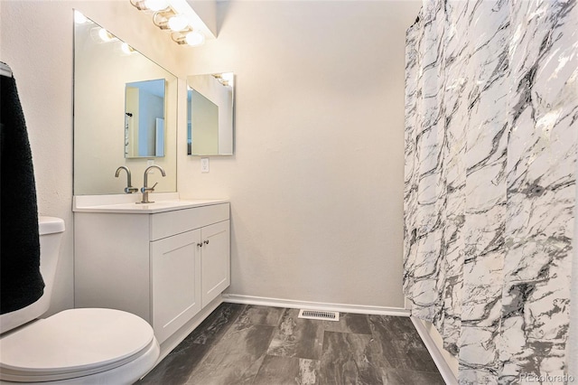 bathroom featuring vanity, toilet, and a shower with shower curtain