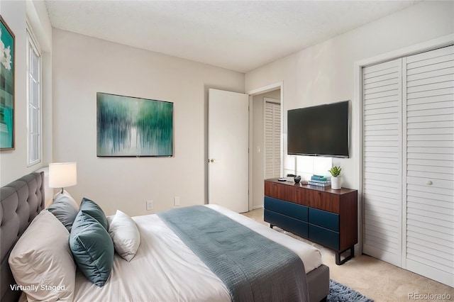 bedroom with multiple windows, light carpet, a textured ceiling, and a closet