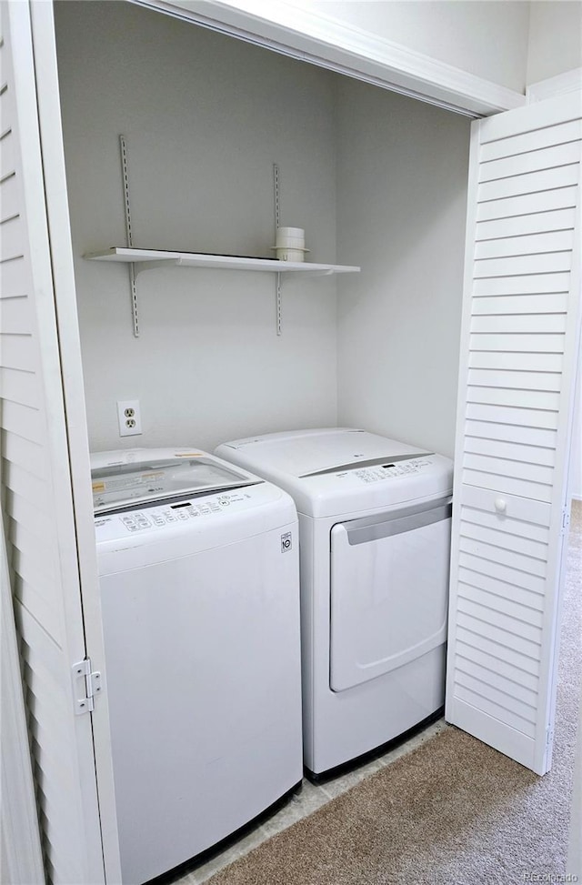 laundry room with separate washer and dryer and light colored carpet