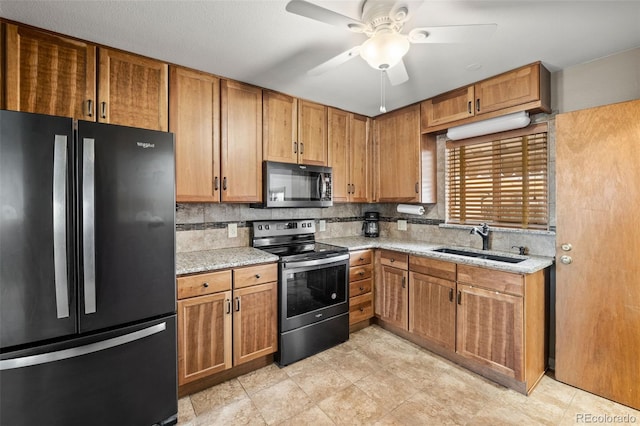 kitchen with stainless steel electric range oven, a sink, freestanding refrigerator, a ceiling fan, and backsplash