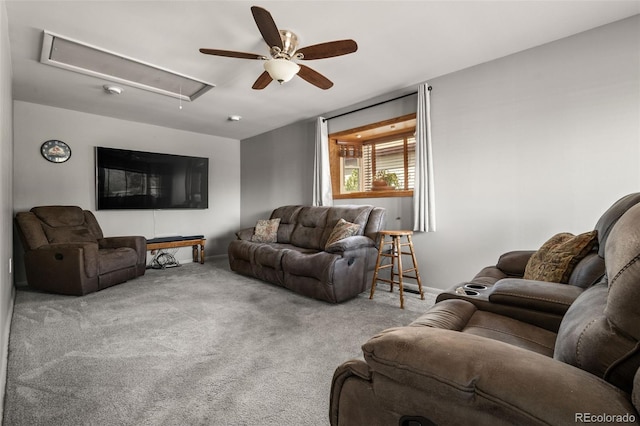 living room featuring baseboards, attic access, carpet, and a ceiling fan