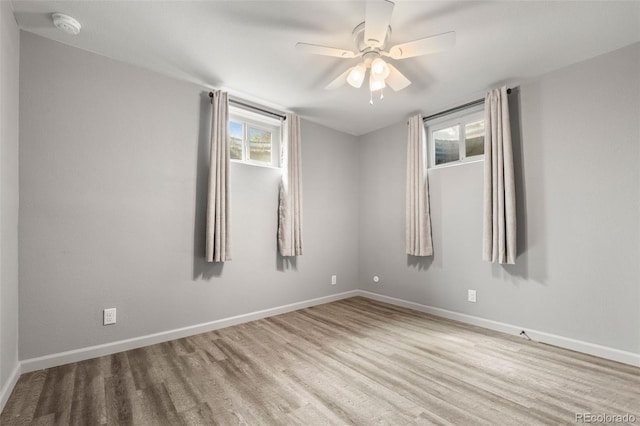 unfurnished room with baseboards, a ceiling fan, and wood finished floors