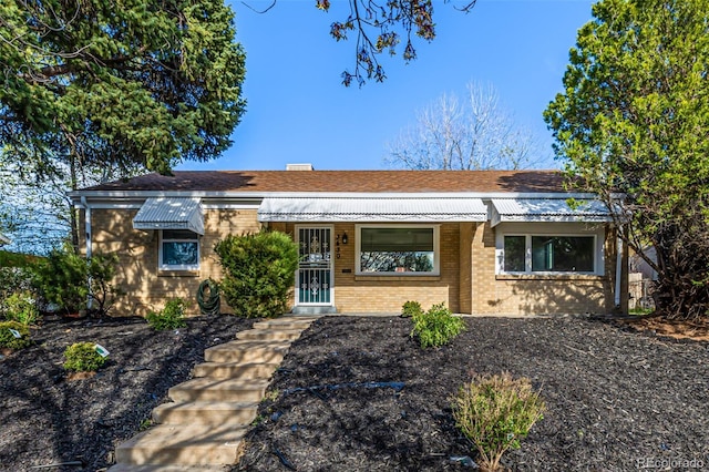 ranch-style home with brick siding and a shingled roof