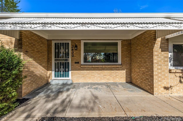 entrance to property featuring brick siding