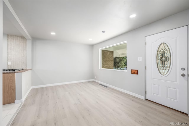 foyer with light wood-style floors, recessed lighting, visible vents, and baseboards