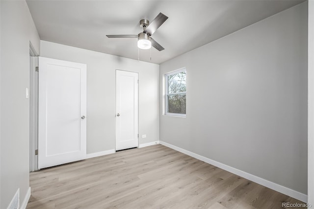 unfurnished bedroom with baseboards, light wood-type flooring, and a ceiling fan