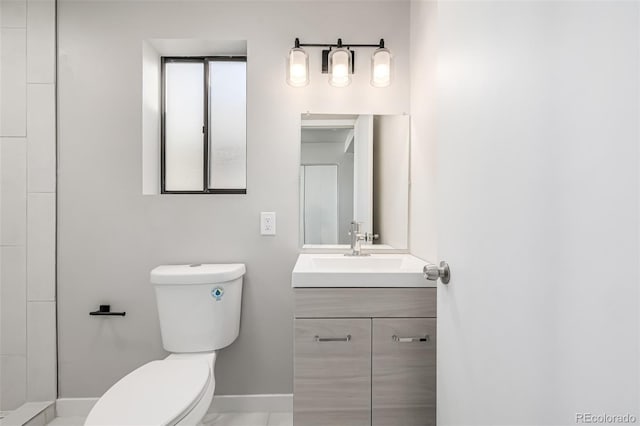 bathroom featuring toilet, vanity, and baseboards