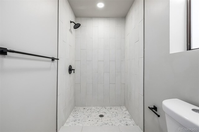 bathroom featuring a tile shower, recessed lighting, and toilet