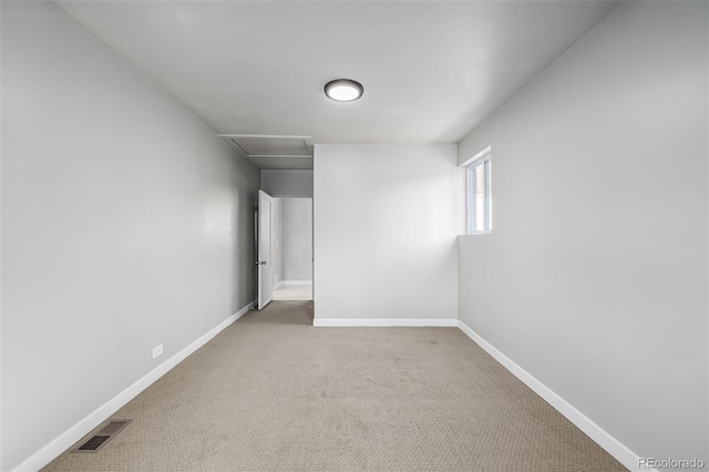 empty room with attic access, baseboards, carpet, and visible vents