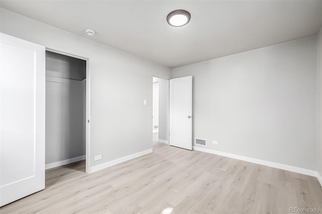 unfurnished bedroom featuring light wood finished floors, baseboards, and visible vents