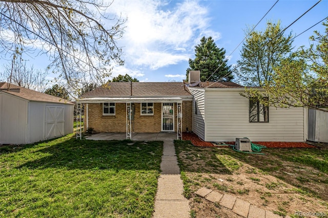rear view of property with central AC, a shed, a patio area, a lawn, and brick siding