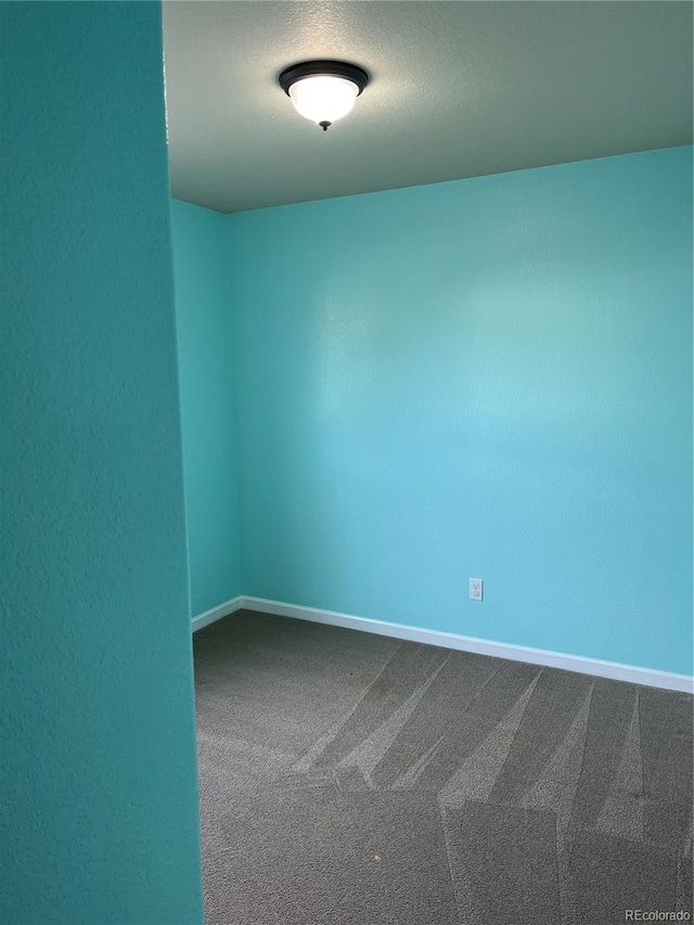 spare room featuring a textured ceiling and carpet