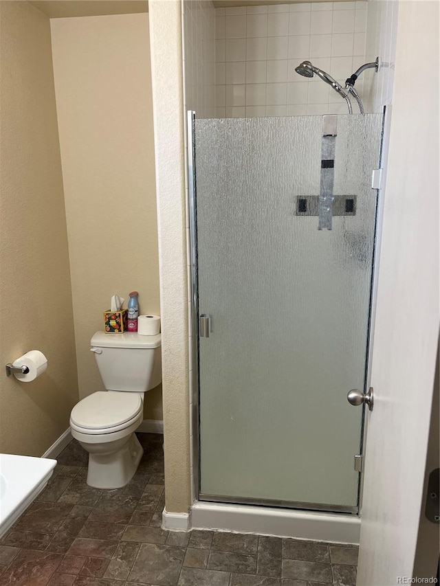 bathroom featuring walk in shower and toilet