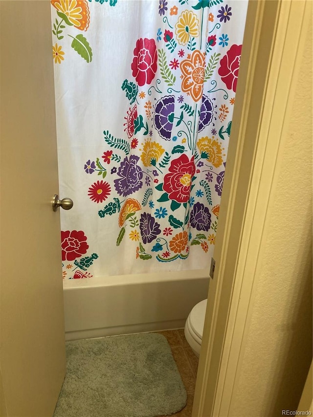 bathroom featuring toilet and shower / bathtub combination with curtain