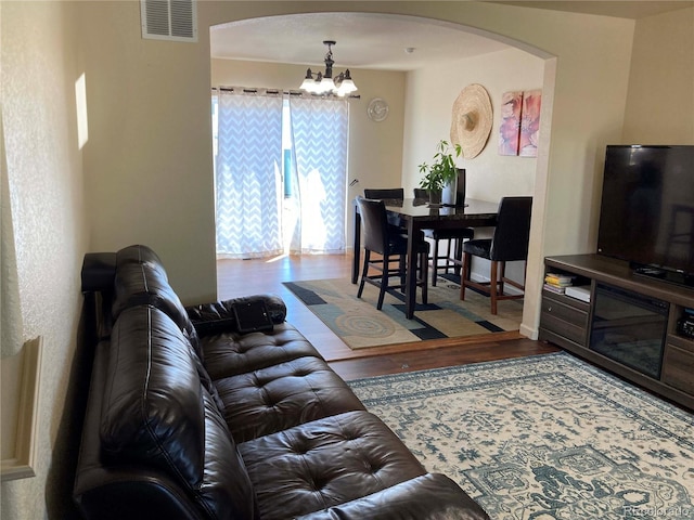 living room with wood-type flooring and a notable chandelier