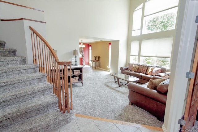 17672 E Weaver Pl, Aurora, CO 80016 - carpeted living area with a high ceiling, stairs, tile patterned flooring, and a chandelier