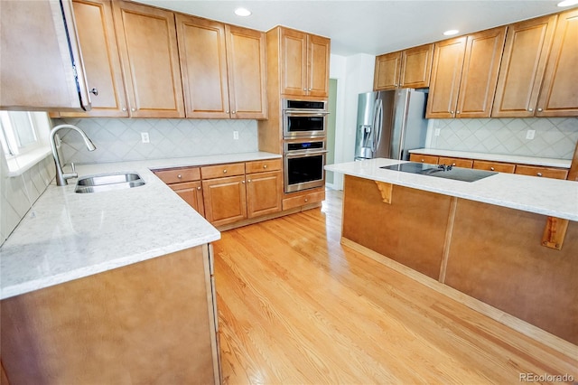 17672 E Weaver Pl, Aurora, CO 80016 - kitchen with appliances with stainless steel finishes, light wood-style floors, decorative backsplash, a breakfast bar area, and light stone countertops