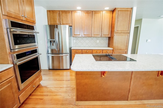 17672 E Weaver Pl, Aurora, CO 80016 - kitchen featuring stainless steel appliances, light wood finished floors, a kitchen breakfast bar, light countertops, and recessed lighting