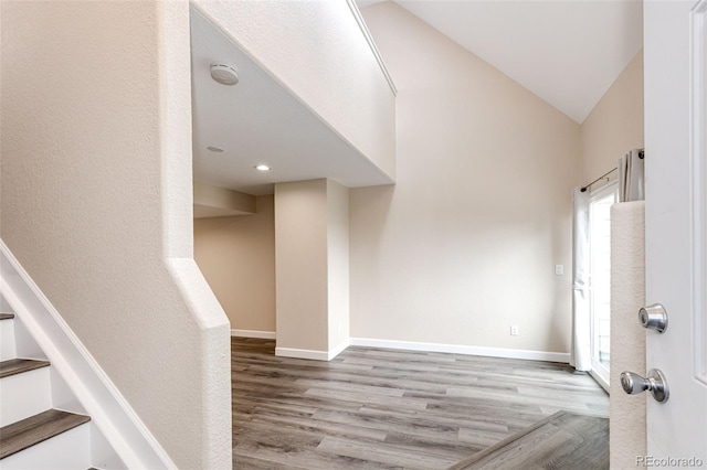 entrance foyer featuring wood finished floors, baseboards, stairs, vaulted ceiling, and recessed lighting