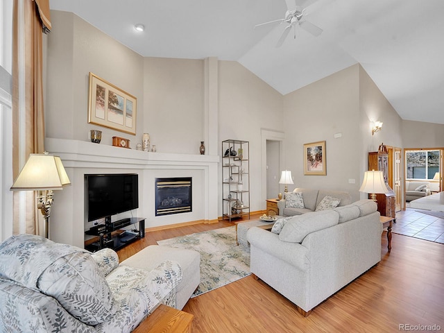 living room featuring ceiling fan, high vaulted ceiling, and hardwood / wood-style flooring