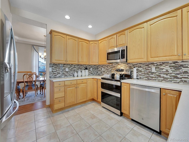 kitchen with an inviting chandelier, decorative backsplash, appliances with stainless steel finishes, decorative light fixtures, and light hardwood / wood-style floors