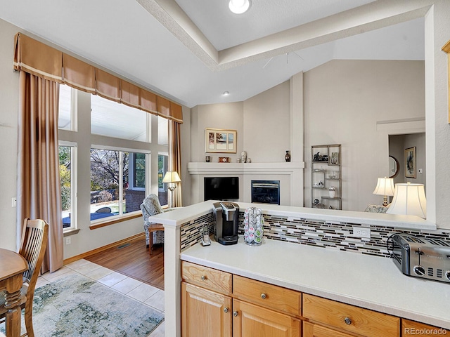 kitchen with light wood-type flooring and vaulted ceiling