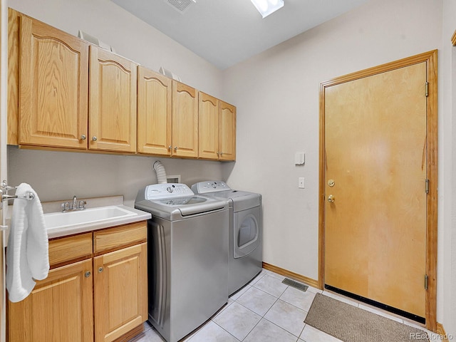 laundry room with washer and dryer, sink, light tile patterned floors, and cabinets