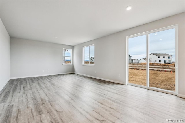 spare room featuring light hardwood / wood-style floors and a healthy amount of sunlight