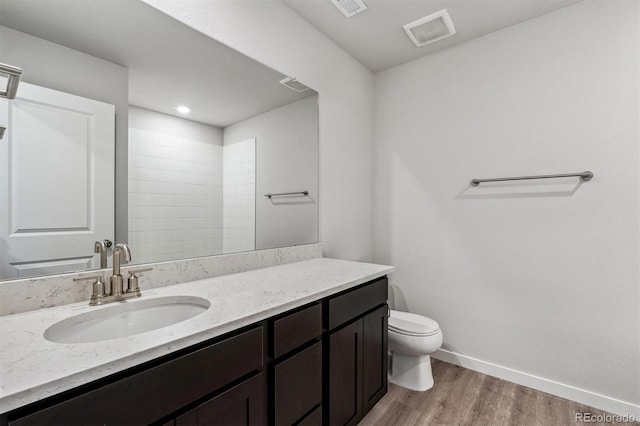 bathroom featuring hardwood / wood-style floors, vanity, toilet, and walk in shower