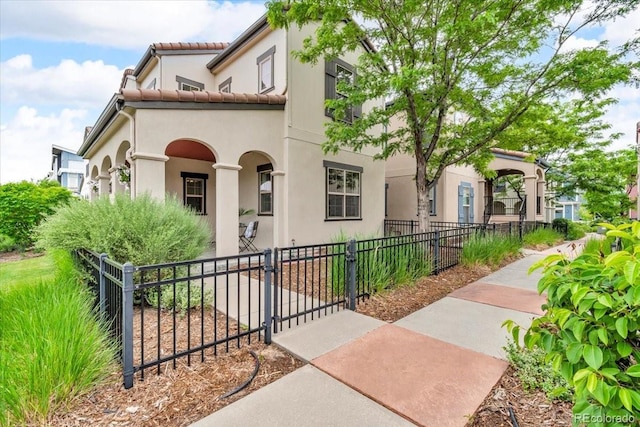 3372 Central Park Blvd, Denver, CO 80238 - mediterranean / spanish-style home with a gate, a fenced front yard, and stucco siding