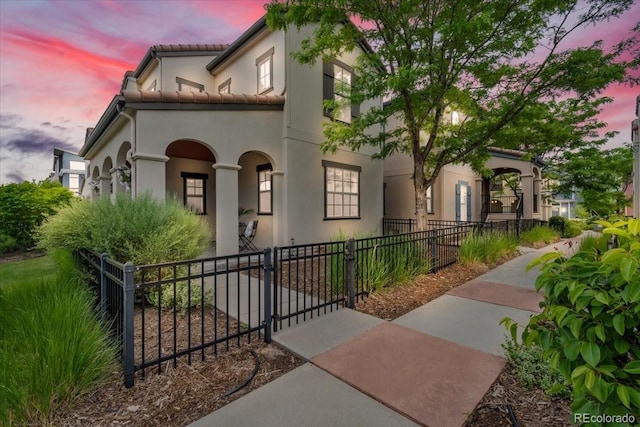 3372 Central Park Blvd, Denver, CO 80238 - mediterranean / spanish-style house with a gate, a fenced front yard, stucco siding, and a tiled roof