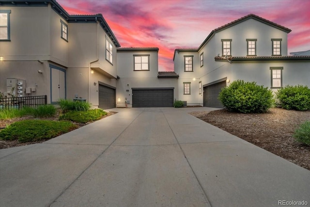 3372 Central Park Blvd, Denver, CO 80238 - view of front of property featuring a garage, concrete driveway, a tile roof, and stucco siding