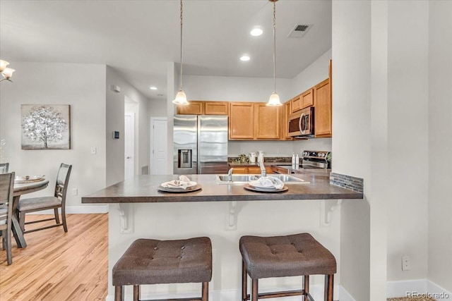 3372 Central Park Blvd, Denver, CO 80238 - kitchen with appliances with stainless steel finishes, a peninsula, pendant lighting, a breakfast bar area, and a sink