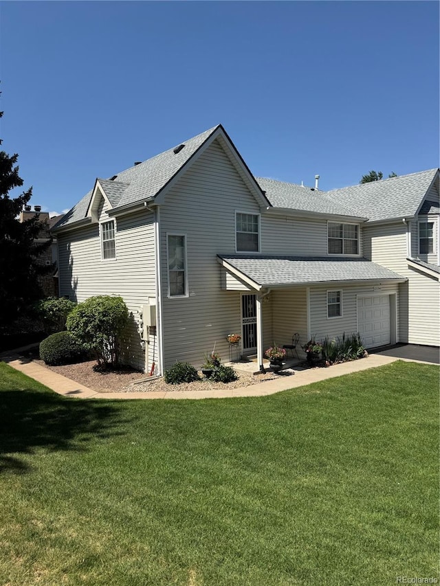 12534 E Pacific Cir Unit A, Aurora, CO 80014 - rear view of property featuring a lawn, a shingled roof, and a garage