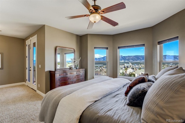 carpeted bedroom with ceiling fan and baseboards