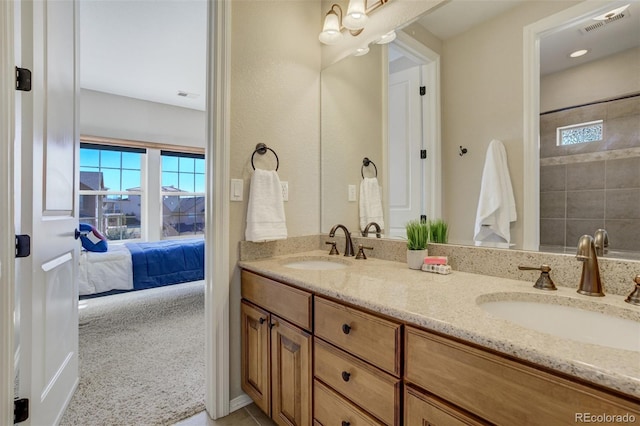 full bath with double vanity, connected bathroom, visible vents, and a sink