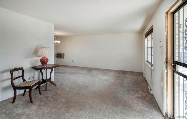 living area with a wall mounted air conditioner, carpet floors, and a chandelier