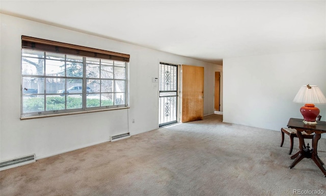 carpeted empty room with a wealth of natural light and visible vents