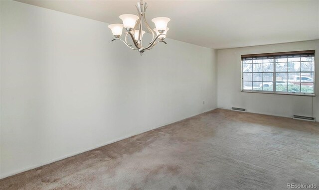 carpeted spare room with a notable chandelier, visible vents, and a baseboard radiator