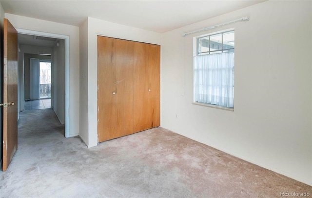 unfurnished bedroom with a closet and carpet floors